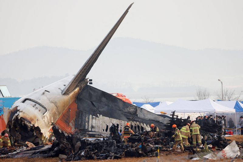 &copy; Reuters. FILE PHOTO: People work at the site where an aircraft went off the runway and crashed at Muan International Airport, in Muan, South Korea, December 30, 2024. REUTERS/Kim Soo-hyeon/File Photo