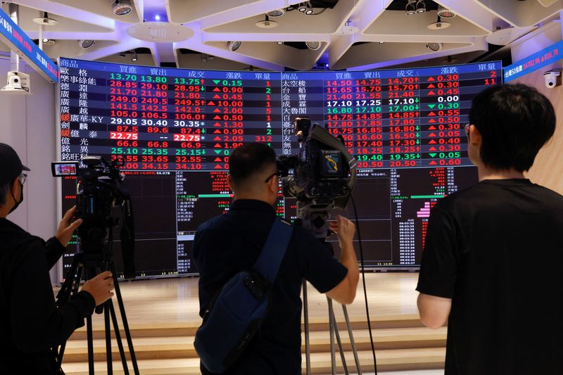 &copy; Reuters. FILE PHOTO: Media members report in front of screens showing trading data at the Taiwan Stock Exchange in Taipei, Taiwan, August 6, 2024. REUTERS/Carlos Garcia Rawlins/File Photo