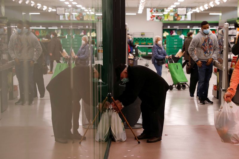 &copy; Reuters. FILE PHOTO: A man prepares to carry bags with groceries after exiting a supermarket in Madrid, Spain, November 29, 2021. REUTERS/Susana Vera/File Photo