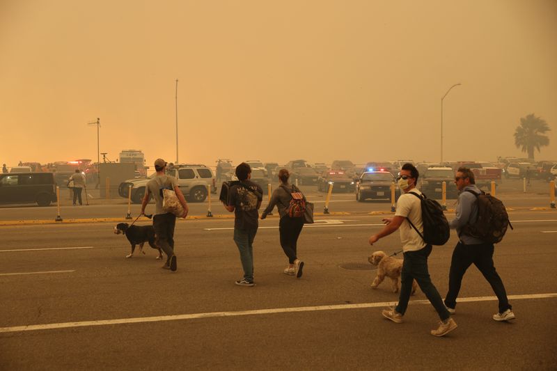 &copy; Reuters. People evacuate, as a wildfire breaks-out near Pacific Palisades on the west side of Los Angeles during a weather driven windstorm in Southern California, January 7, 2025.  REUTERS/Mike Blake