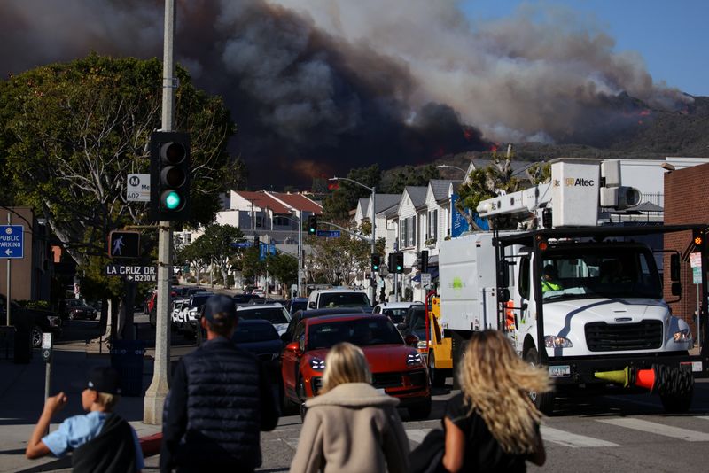 © Reuters. Smoke rises from a wildfire burning near Pacific Palisades on the west side of Los Angeles during a weather driven windstorm, in Los Angeles, California, January 7, 2025.  REUTERS/Daniel Cole