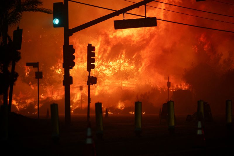 © Reuters. A traffic light turns green on the Pacific Coast Highway as wildfires rage in the Pacific Palisades neighborhood west of Los Angeles, California, January 7, 2025. Photograph: Daniel Cole/Reuters