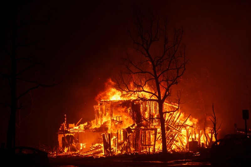 © Reuters. Flames engulf a structure as the Eaton Fire burns in Pasadena, California, U.S. January 7, 2025. REUTERS/Mario Anzuoni