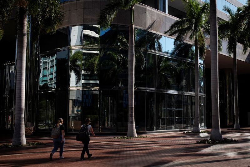 &copy; Reuters. FILE PHOTO: People walk past palm trees in an office building plaza at the Brickell neighborhood, known as the financial district, in Miami, Florida, U.S., February 23, 2023. REUTERS/Marco Bello/File Photo