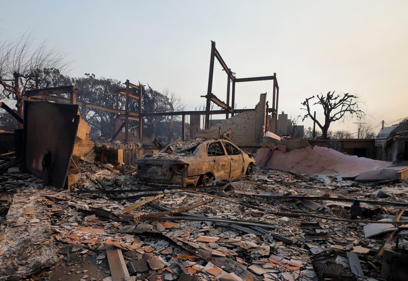 &copy; Reuters. A destroyed car stands amid the rubble of a burnt home as powerful winds fueling devastating wildfires in the Los Angeles area force people to evacuate, in the Pacific Palisades neighborhood of west Los Angeles, California, U.S. January 8, 2025. REUTERS/M