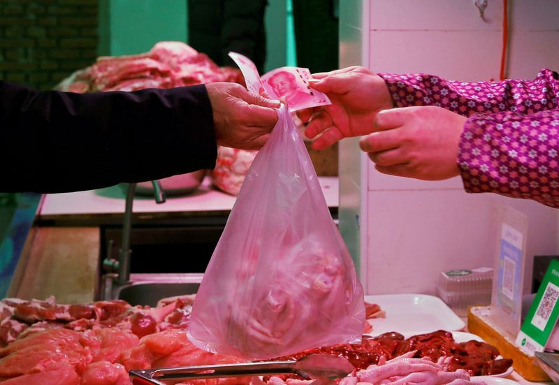 © Reuters. FILE PHOTO: A man pays for meat at a market in Beijing, China, January 11, 2021. REUTERS/Tingshu Wang/File Photo