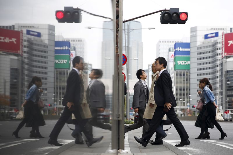 © Reuters. FILE PHOTO: People cross a street in a business district in central Tokyo, Japan, December 8, 2015.  REUTERS/Thomas Peter/ File Photo