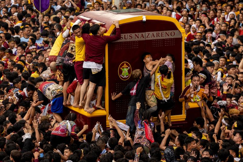 © Reuters. Filipino Catholic devotees jostle to touch the carriage carrying the statue of the Black Nazarene during the annual procession on its feast day in Manila, Philippines, January 9, 2025. REUTERS/Eloisa Lopez