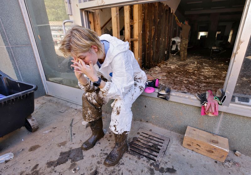 &copy; Reuters. FILE PHOTO: Brenna Peake, 25-year old volunteer from Asheville, reacts to what she said was exhaustion as she helps clean up businesses and other properties in the aftermath of Hurricane Helene, in Marshall, North Carolina, U.S. October 10, 2024. REUTERS/