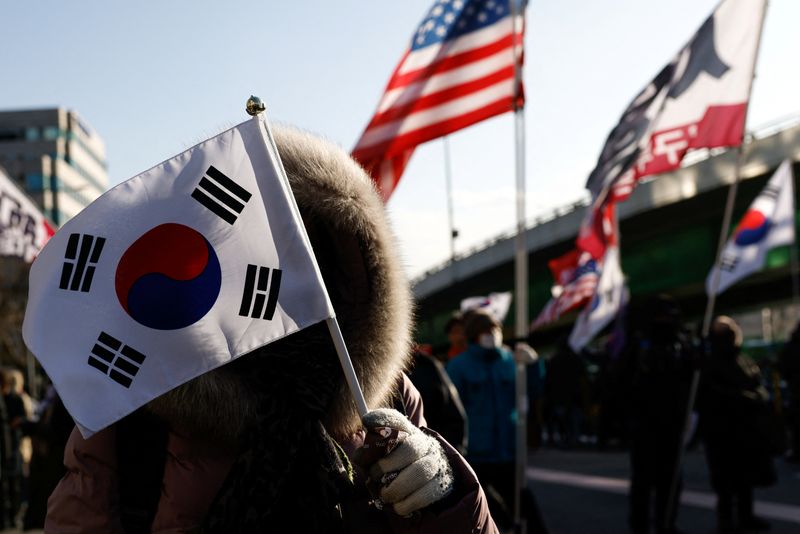 © Reuters. Pro-Yoon demonstrators hold U.S. and Korean flags as they take part in a rally in support of impeached South Korean President Yoon Suk Yeol near his official residence in Seoul, South Korea January 9, 2025. REUTERS/Tyrone Siu