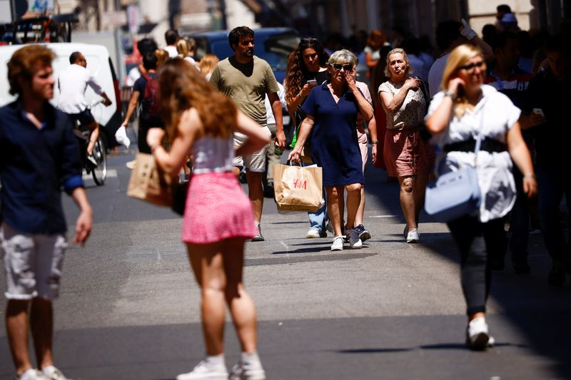 © Reuters. FILE PHOTO: People carry shopping bags as they walk down a shopping street in Rome, Italy, June 15, 2022. REUTERS/Guglielmo Mangiapane/File Photo