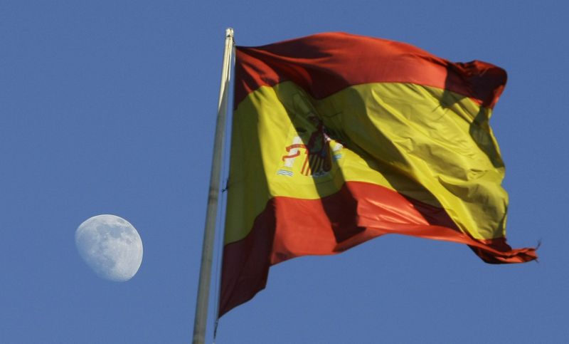 &copy; Reuters. La luna sorge accanto a una bandiera spagnola nel centro di Madrid, 26 gennaio 2010. REUTERS/Andrea Comas