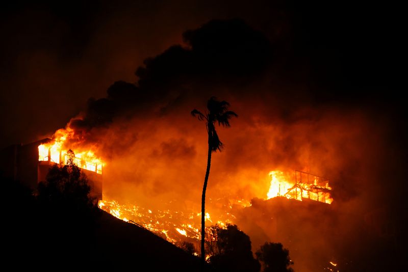 &copy; Reuters. Smoke and flames engulf houses, as powerful winds fueling devastating wildfires in the Los Angeles area force people to evacuate, in the Pacific Palisades neighborhood on the west side of Los Angeles, California, U.S. January 8, 2025. REUTERS/Daniel Cole