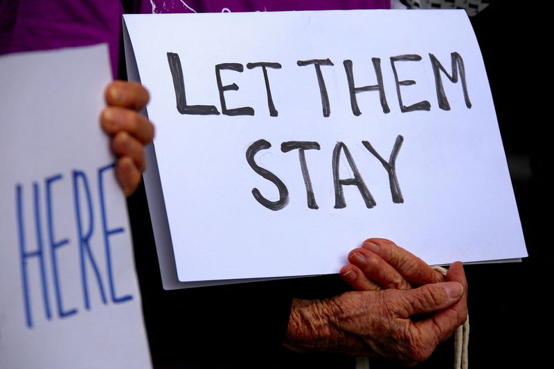 &copy; Reuters. FILE PHOTO: Refugee advocates hold signs as they protest against the detention of asylum seekers being held at Australian-run offshore detention centers located on Papua New Guinea's Manus Island, and the South-Pacific island of Nauru, in central Sydney, 