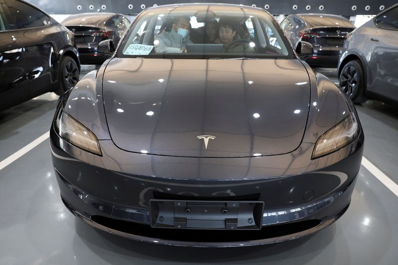 © Reuters. Customers sit in a Tesla Model Y electric vehicle (EV) at the carmaker's delivery centre in Beijing, China January 8, 2025. REUTERS/Florence Lo