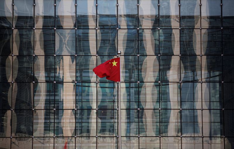 © Reuters. FILE PHOTO: A Chinese national flag flutters at the headquarters of a commercial bank on a financial street near the headquarters of the People's Bank of China, China's central bank, in central Beijing November 24, 2014.   REUTERS/Kim Kyung-Hoon/File Photo