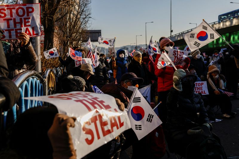 © Reuters. Pro-Yoon demonstrators hold U.S. and South Korean flags as they take part in a rally in support of impeached South Korean President Yoon Suk Yeol near his official residence in Seoul, South Korea January 10, 2025. REUTERS/Tyrone Siu