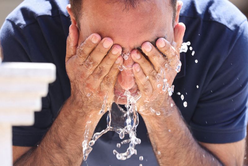 &copy; Reuters. FILE PHOTO: A tourist uses a fountain to cool off amid a heatwave, in Sarajevo, Bosnia and Herzegovina, August 13, 2024. REUTERS/Amel Emric/File Photo