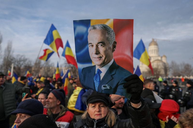 © Reuters. A supporter holds a picture of Romanian far-right presidential election candidate Calin Georgescu during a demonstration outside the constitutional court, where Georgescu is expected to file some documents to the judicial authorities, in Bucharest, Romania, January 10, 2025. Inquam Photos/George Calin via REUTERS