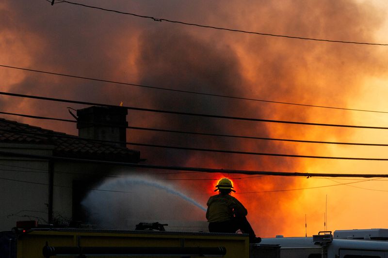 &copy; Reuters. FILE PHOTO: A firefighter battles the Palisades Fire as it burns during a windstorm on the west side of Los Angeles, California, U.S. January 8, 2025. REUTERS/Ringo Chiu/File Photo