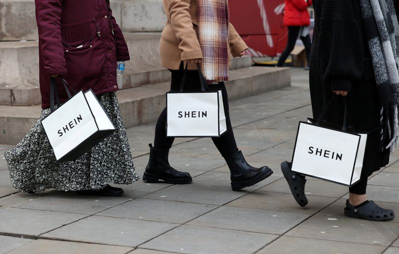 &copy; Reuters. FILE PHOTO: Shoppers carry bags with promotional merchandise as they visit fashion retailer Shein's Christmas bus tour, in Manchester, Britain, December 13, 2024. REUTERS/Temilade Adelaja/File Photo