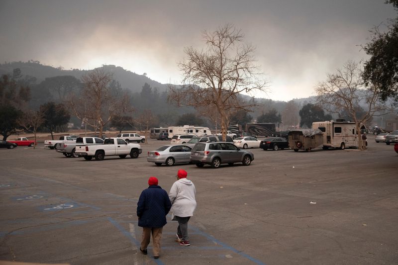 &copy; Reuters. Dorthy Brown and her daughter walk through the parking lot of the Rose Bowl, as powerful winds fueling devastating wildfires in Los Angeles area forced people to evacuate, in Pasadena, California, U.S. January 8, 2025. REUTERS/Zaydee Sanchez