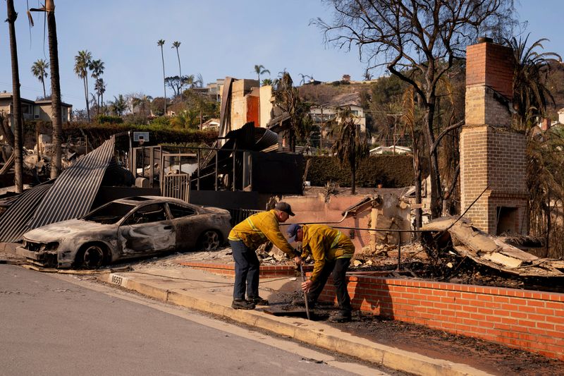 © Reuters. Firefighters shut off water to stop leaks at damaged homes after the Palisades Fire in the Pacific Palisades neighborhood in Los Angeles, California, US January 10, 2025. REUTERS/David Ryder