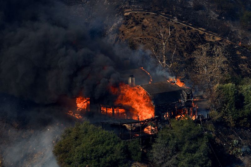 © Reuters. A house burns as the Palisades Fire burns in Mandeville Canyon, in Los Angeles, California, US, January 11, 2025. REUTERS/Shannon Stapleton      