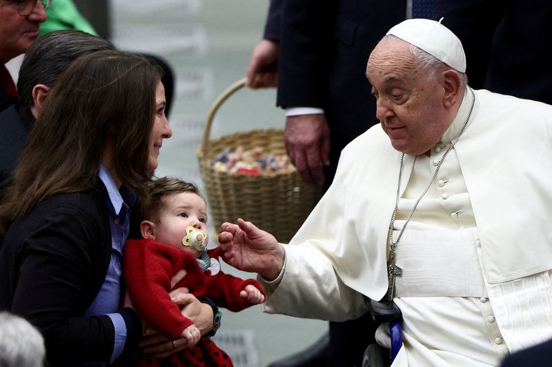 © Reuters. Pope Francis greets a child at a jubilee ceremony in the Paul VI Hall in the Vatican on January 11, 2025. REUTERS/Guglielmo Mangiapane  