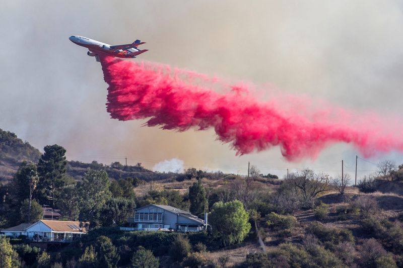 Aerial assault aims to stem LA Palisades fire eastward spread