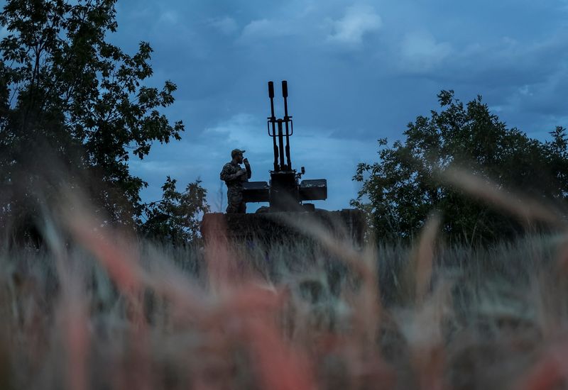 © Reuters. FILE PHOTO: A Ukrainian serviceman from an anti-drone mobile air defence unit smokes near a ZU-23-2 anti aircraft cannon as he waits for Russian kamikaze drones, amid Russia's attack on Ukraine, in Kherson region, Ukraine June 11, 2024. REUTERS/Ivan Antypenko/File Photo