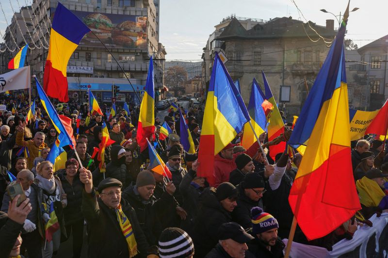 © Reuters. Protesters wave Romanian national flags during a demonstration organized by Romania's far-right Alliance for Uniting Romanian (AUR) party, urging the government to re-hold presidential elections, in Bucharest, Romania, 12 January, 2025. REUTERS/Andreea Campeanu