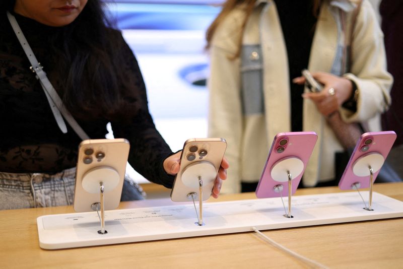 &copy; Reuters. FILE PHOTO: Women use Apple iPhone smartphones displayed at a store in London, Britain, October 6, 2024. REUTERS/Hollie Adams/File Photo