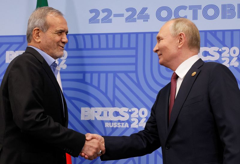 &copy; Reuters. Il presidente russo Vladimir Putin stringe la mano al presidente iraniano Masoud Pezeshkian durante un incontro a margine del vertice Brics a Kazan, Russia, il 23 ottobre 2024. REUTERS/Maxim Shemetov