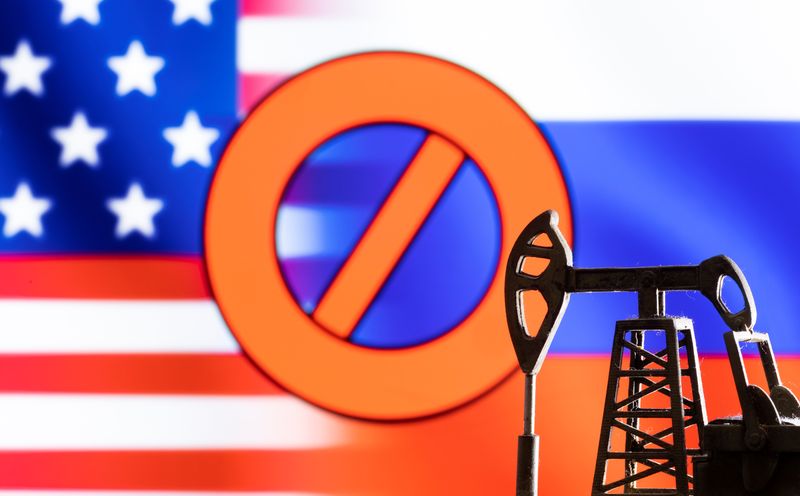 © Reuters. FILE PHOTO: A model of a pump jack is seen in front of the displayed sign 