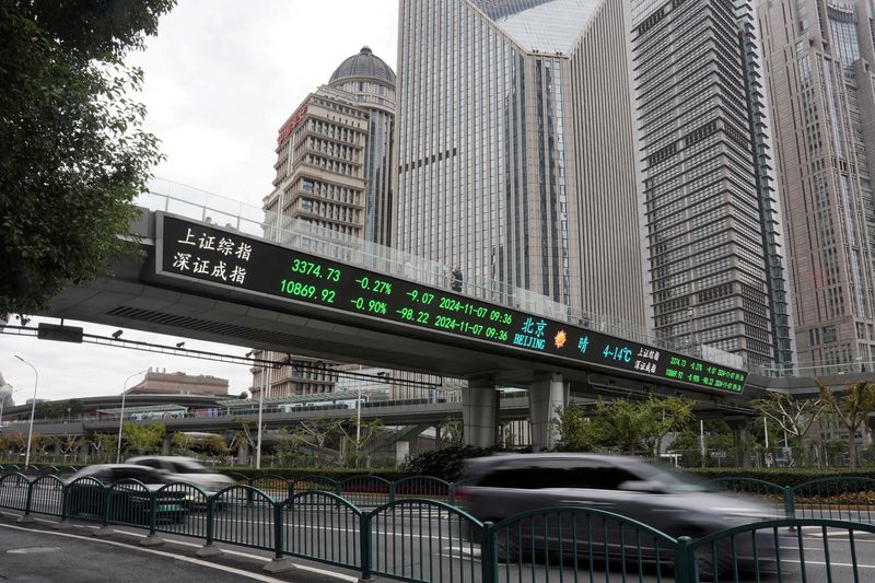 © Reuters. FILE PHOTO: Vehicles pass through a pedestrian overpass with goods information in the Lujiazui financial district in Shanghai, China, November 7, 2024. REUTERS/Nicoco Chan/File Photo