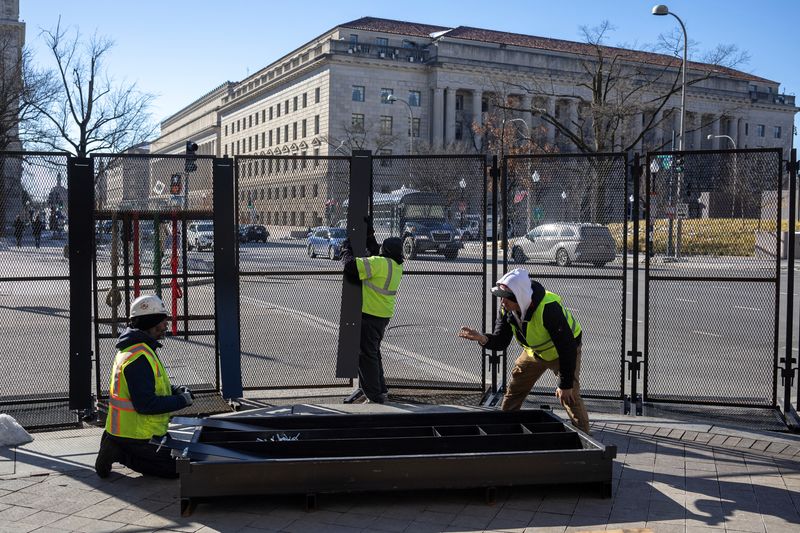 © Reuters. Workers erect security fencing on Pennsylvania Avenue, ahead of the presidential inauguration of U.S. President-elect Donald Trump, in Washington, U.S., January 14, 2025. REUTERS/Marko Djurica