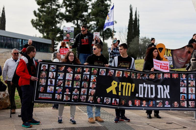 ©Reuters. Families and supporters of Israeli hostages kidnapped in a deadly attack by Hamas on October 7, 2023, held in Gaza, hold banners outside a meeting between hostage representatives and Israeli Prime Minister Benjamin. They gathered to demand an agreement to take back all the hostages. Prime Minister Netanyahu, Jerusalem, January 14, 2025. Reuters/Ammar Awad