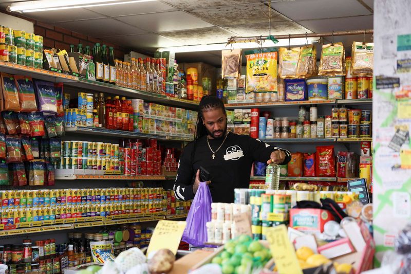 © Reuters. FILE PHOTO: A customer shops at Ridley Road Market, ahead of Labour's budget, in London, Britain, October 28, 2024. REUTERS/Mina Kim/File Photo