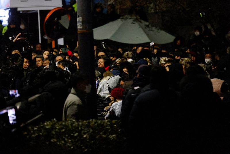 © Reuters. Members of the People Power Party confront police officers as authorities seek to execute an arrest warrant against deposed South Korean President Yoon Suk-yeol, in Seoul, South Korea, January 15, 2025. REUTERS/Tyrone Seo