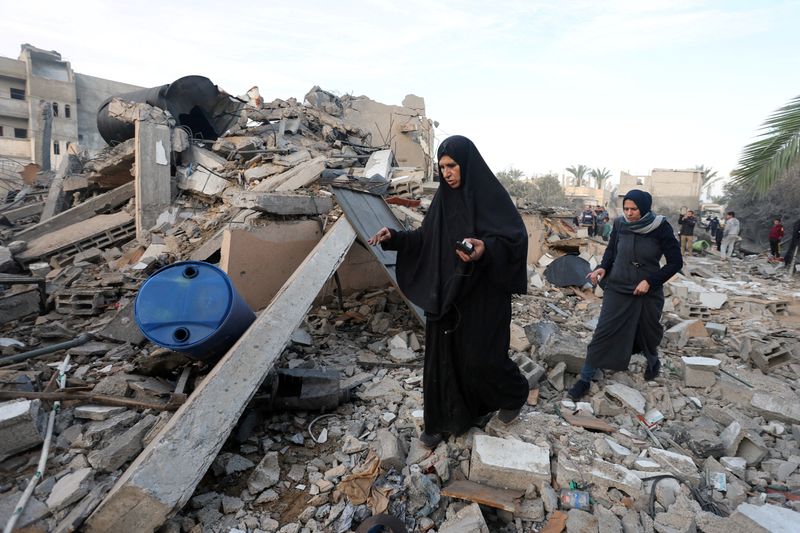 &copy; Reuters. Palestinesi ispezionano il luogo di un attacco israeliano a una casa, nel corso del conflitto in corso tra Israele e Hamas, a Deir Al-Balah, nella Striscia di Gaza centrale, 15 gennaio 2025. REUTERS/Ramadan Abed