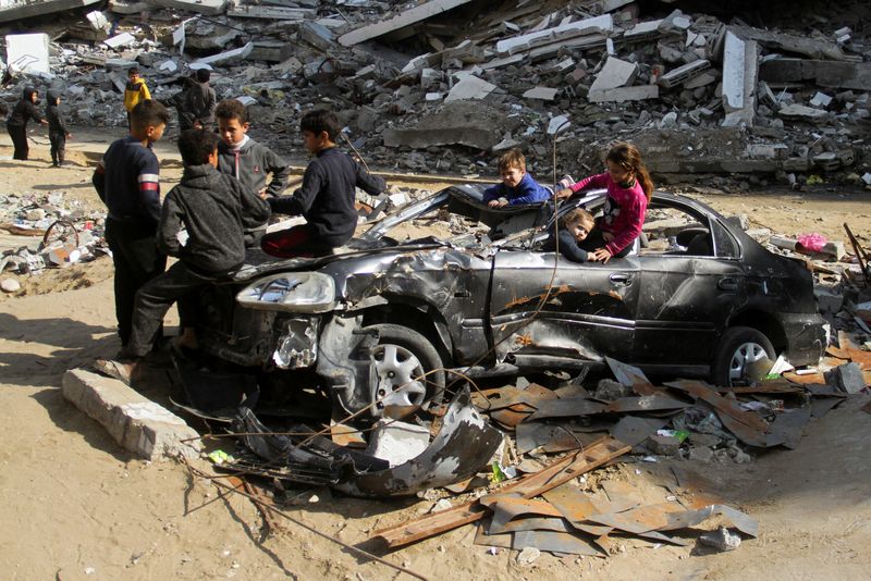 &copy; Reuters. Palestinian children play in a destroyed car near the rubble of houses destroyed in previous Israeli strikes, amid ceasefire negotiations with Israel, in Gaza City, January 15, 2025. REUTERS/Mahmoud Issa     