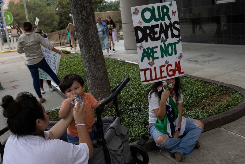 &copy; Reuters. FILE PHOTO: Deferred Action for Childhood Arrivals policy recipients Susana Lujano, 30, provides water to her one year old son Joaquin next to Brendaletzy Lopez, 30, who holds a placard ahead of a hearing on the DACA program outside the federal courthouse