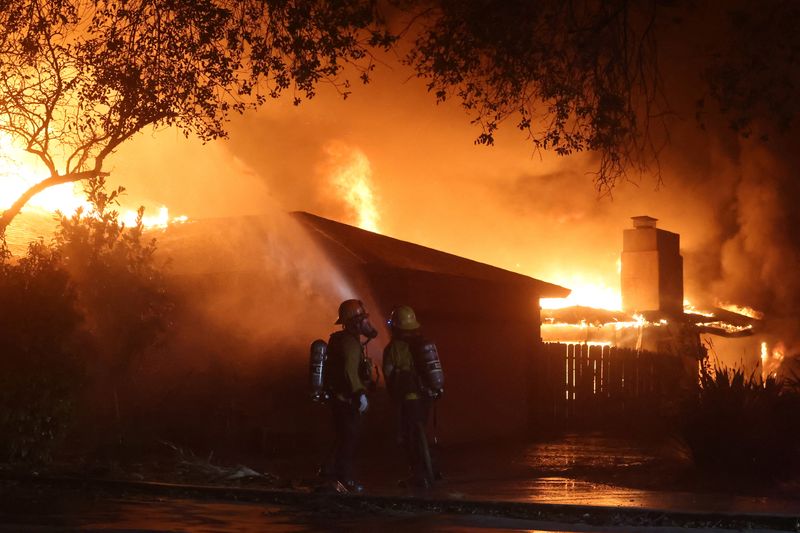 © Reuters. Firefighters work during the Eaton Fire in Pasadena, California, US, January 8, 2025. REUTERS/Mario Anzuoni