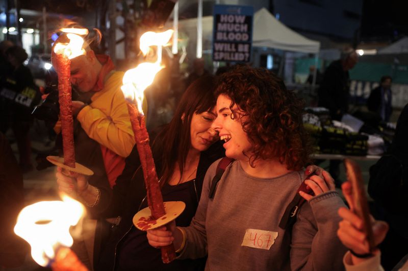 &copy; Reuters. Supporters of Israeli hostages, who were kidnapped during the deadly October 7 2023 attack by Hamas, hold torches as they attend a protest to demand a deal to bring every hostage home at once, amid Gaza ceasefire negotiations, in Tel Aviv, Israel, January