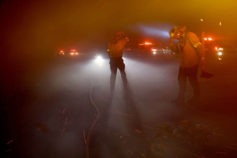 &copy; Reuters. FILE PHOTO: Firefighters protect themselves from strong winds through thick smoke during the Eaton Fire in Pasadena, California, U.S., January 7, 2025. REUTERS/Mario Anzuoni/File Photo