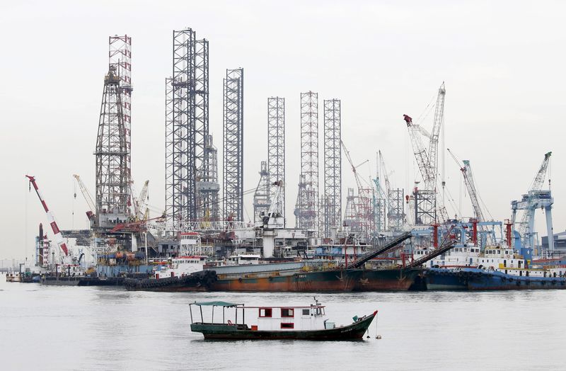 © Reuters. Offshore drilling platforms (rear) stand together at a dock yard near Singapore port November 2, 2015. REUTERS/Tim Wimborne/File Photo