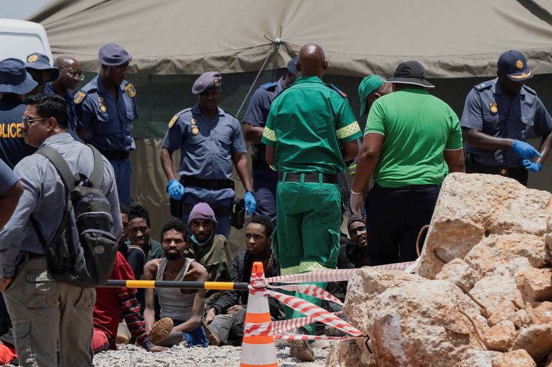 &copy; Reuters. Rescued miners are seen as they are processed by police after being rescued at the mine shaft where rescue operations are ongoing as attempts are made to rescue illegal miners who have been underground for months, in Stilfontein, South Africa, January 14,