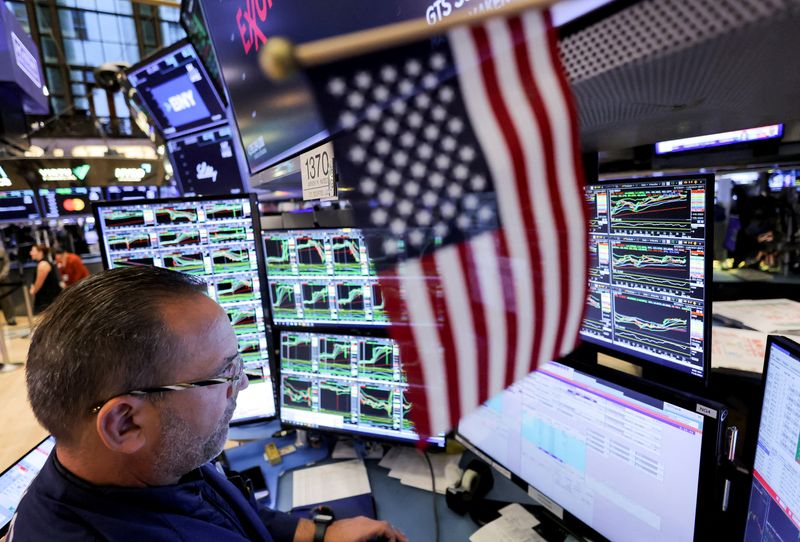 © Reuters. FILE PHOTO: A trader works at the New York Stock Exchange (NYSE) next to a U.S. flag, after Republican Donald Trump won the U.S. presidential election, in New York City, U.S., November 6, 2024. REUTERS/Andrew Kelly/File Photo