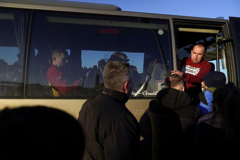 © Reuters. FILE PHOTO: A bus driver turns people away, after filling his vehicle with evacuees who have just crossed the border, fleeing the violence in Ukraine, in Medyka, Poland, February 24, 2022. REUTERS/Bryan Woolston/File Photo